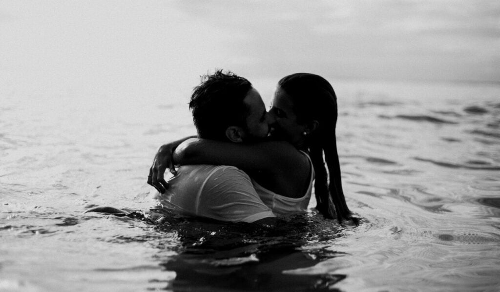 Man woman kiss each other in the water