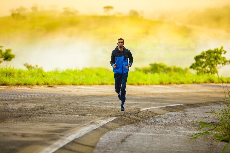 Man jogging on a country road at sunrise